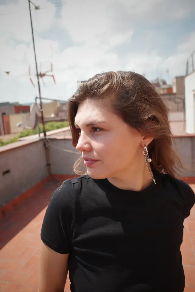 A close portrait of a person on a rooftop, looking down