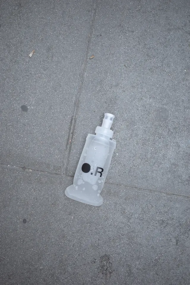 A clear bottle lying on concrete