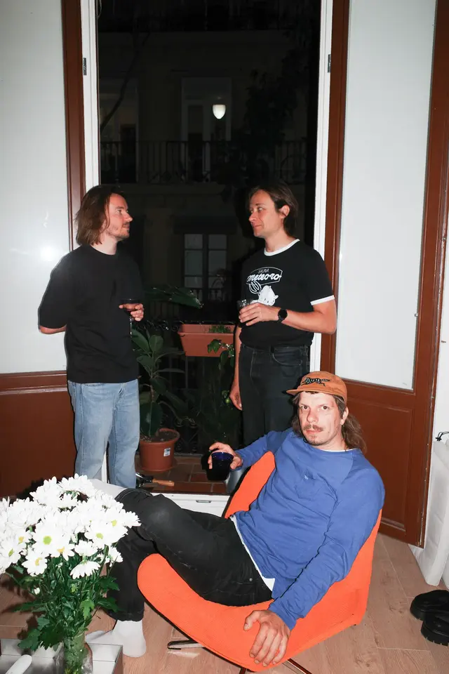 Two people in a doorway, one sitting in a blue chair