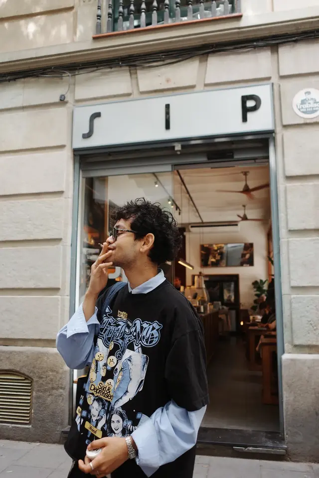 A person leaning out of an open window above the street